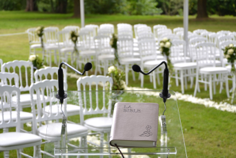 Cérémonie d'un mariage en extérieur avec des chaises blanches